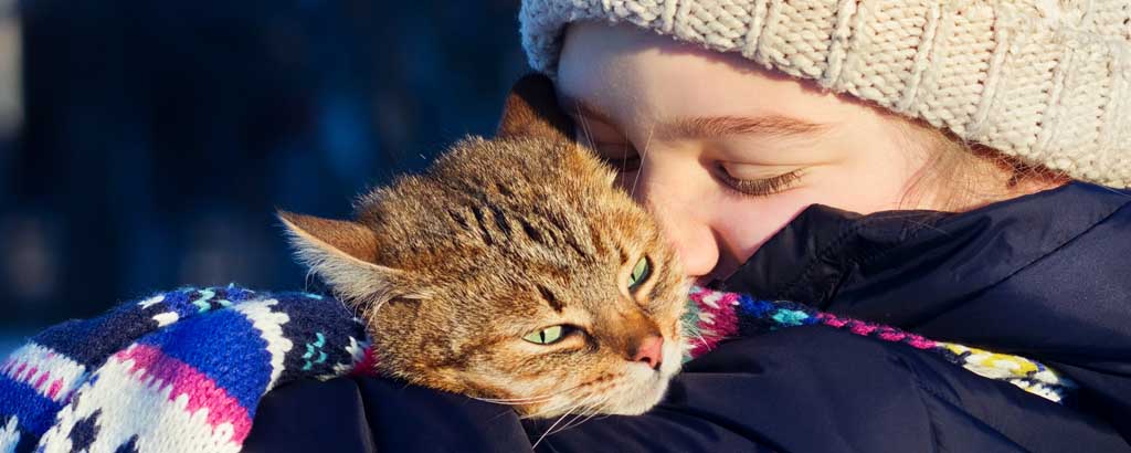 ung flicka kramar om sin katt